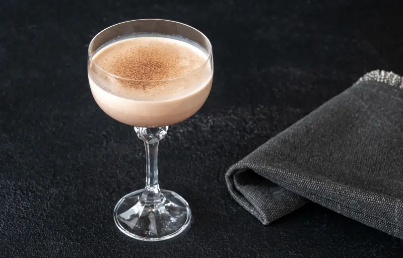 Alexander cocktail lavet med Creme de Cacao og Cognac, serveret i et glas.