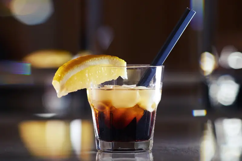 Black Russian cocktail drink, mixet af vodka og kaffelikør, serveret på en bar i et lowball glas.