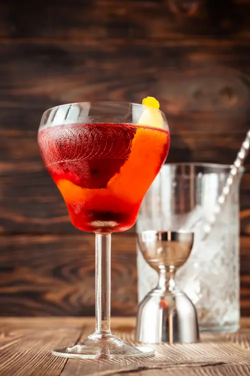 Boulevardier cocktail serveret i et lowball glas på en bardisk.